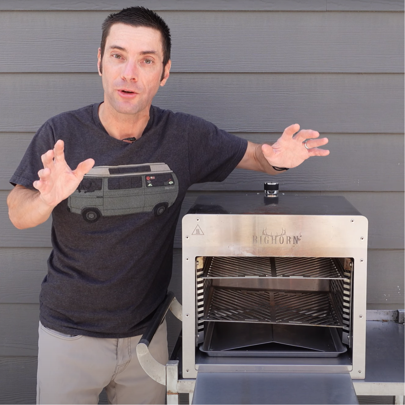 The image shows a man enthusiastically demonstrating a "BIGHORN" oven or grill.