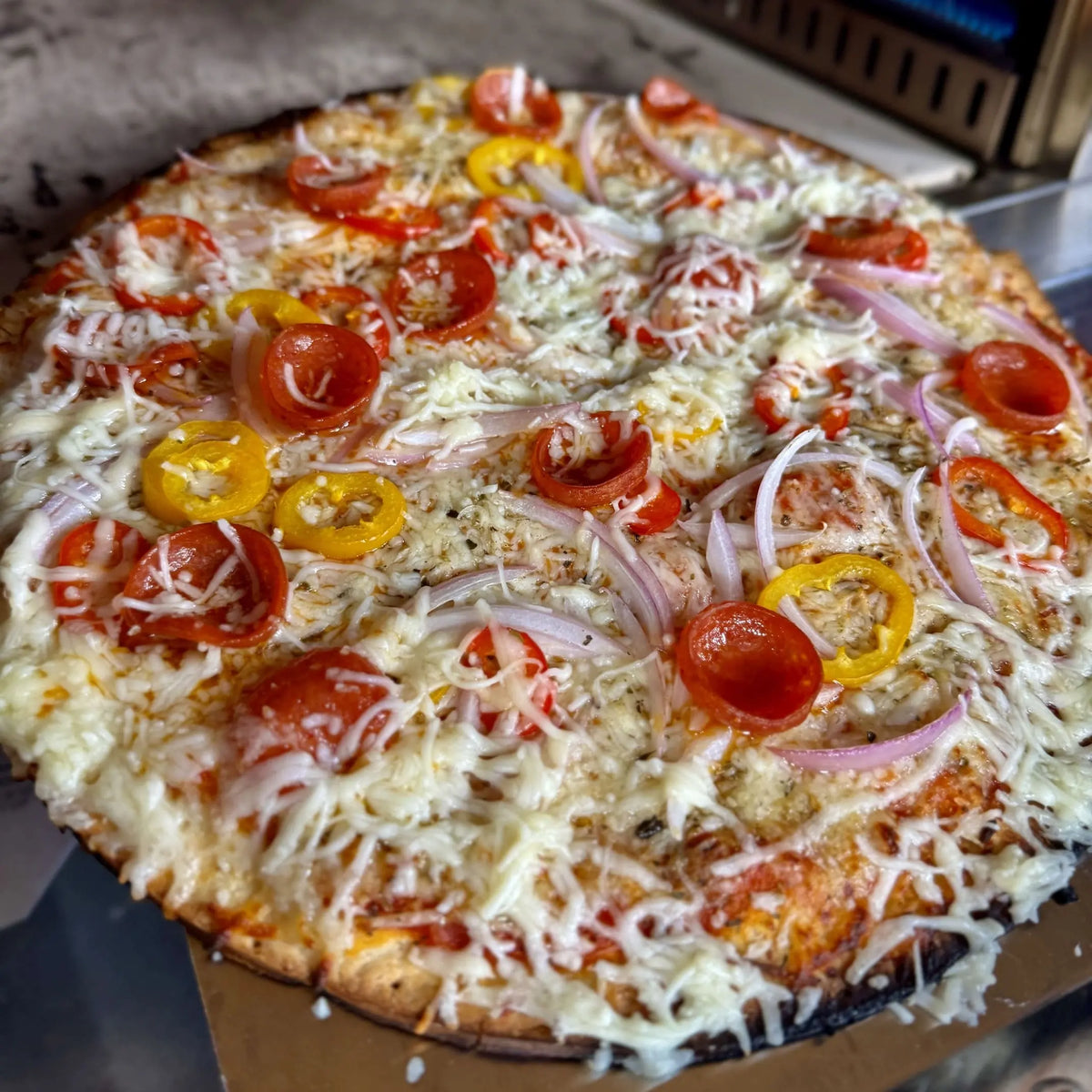 Unbaked pizza topped with vegetables, pepperoni, and shredded cheese