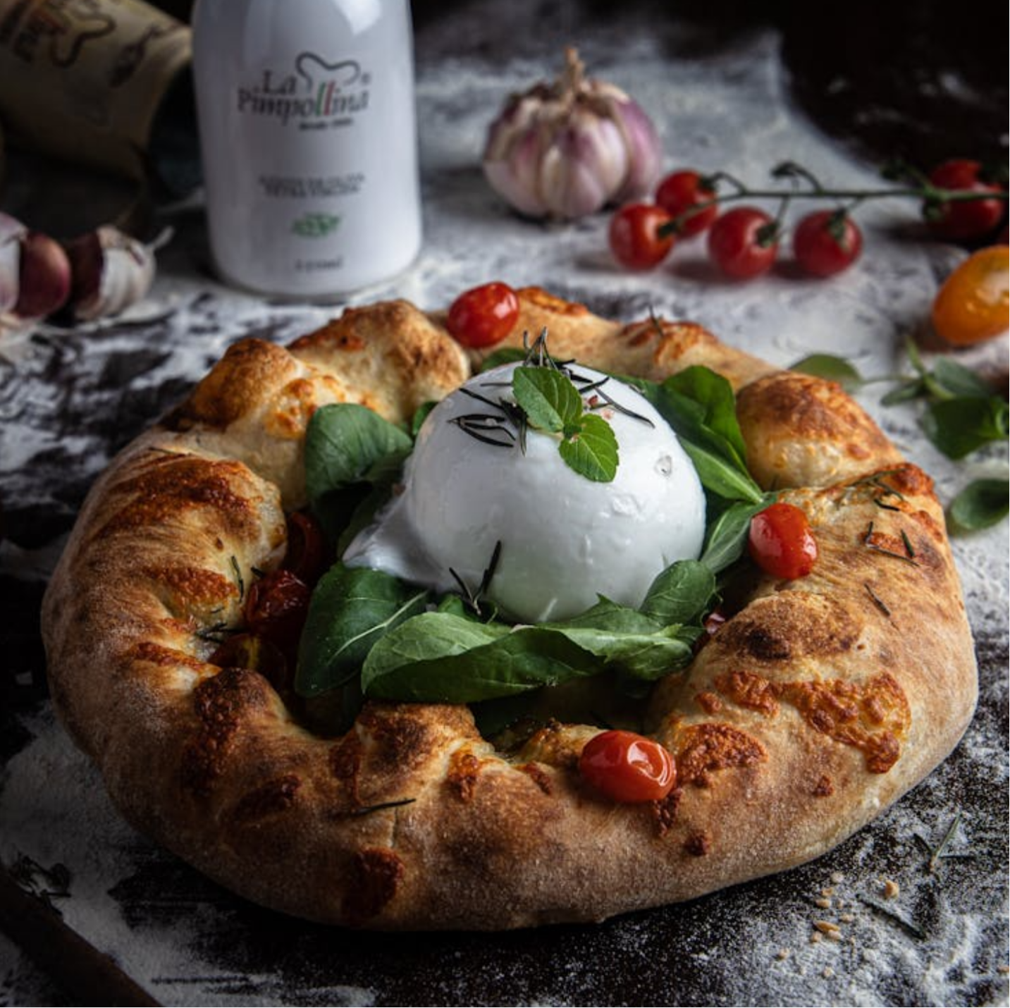 Artisanal pizza with fresh burrata, arugula, and cherry tomatoes.