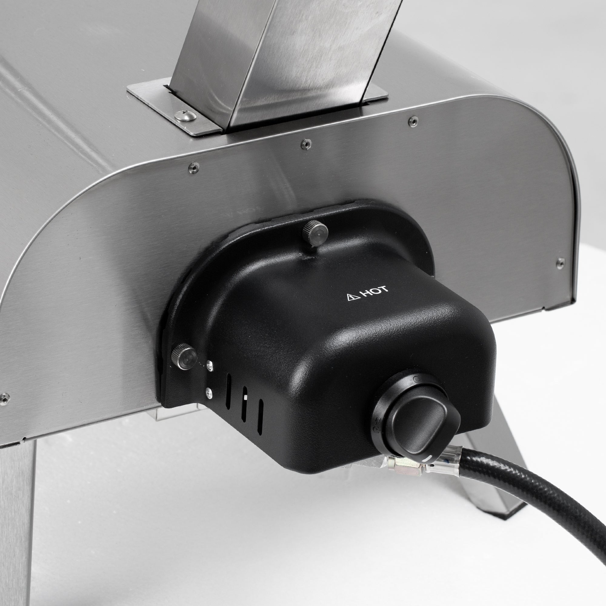 Propane gas burner unit attached to stainless steel pizza oven, featuring "A HOT" text, ready for cooking.