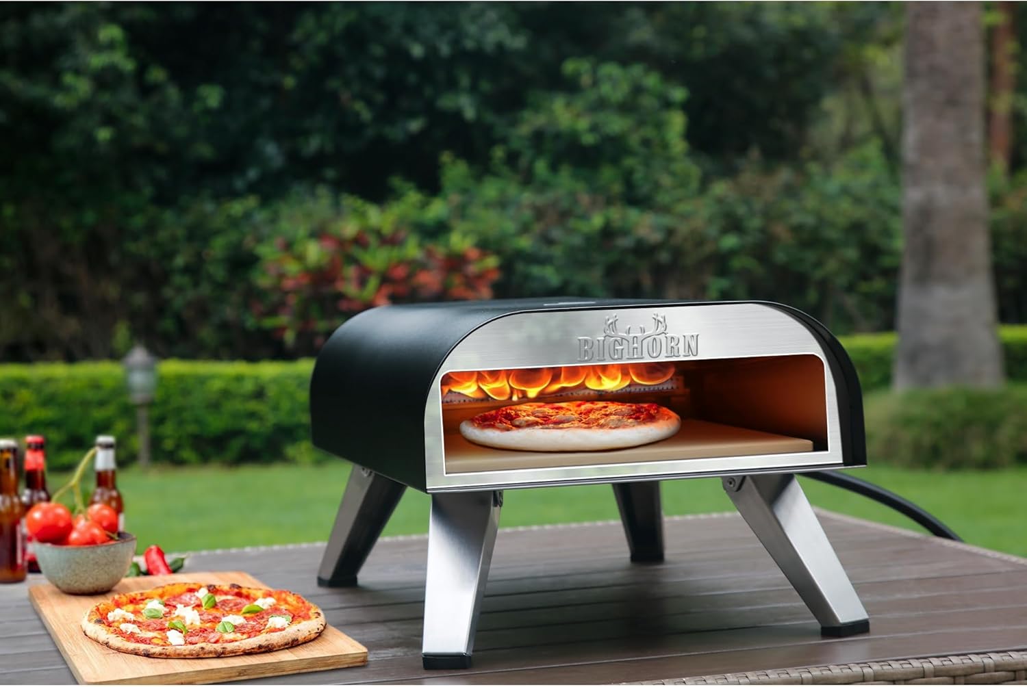 Big Horn 12" Black Portable Gas Pizza Oven with pizza cooking, outdoor cooking setup