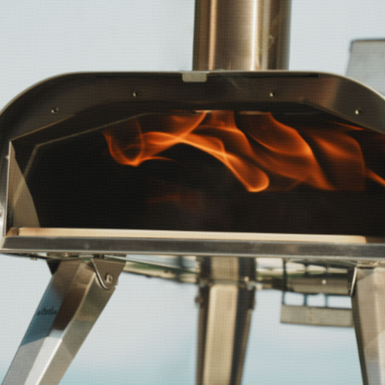 tainless steel outdoor pizza oven with visible flames inside