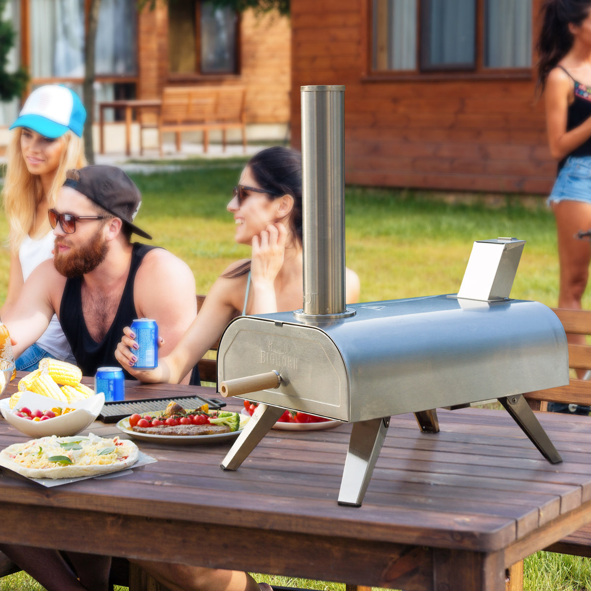 Friends enjoying outdoor cooking with a Big Horn pizza oven